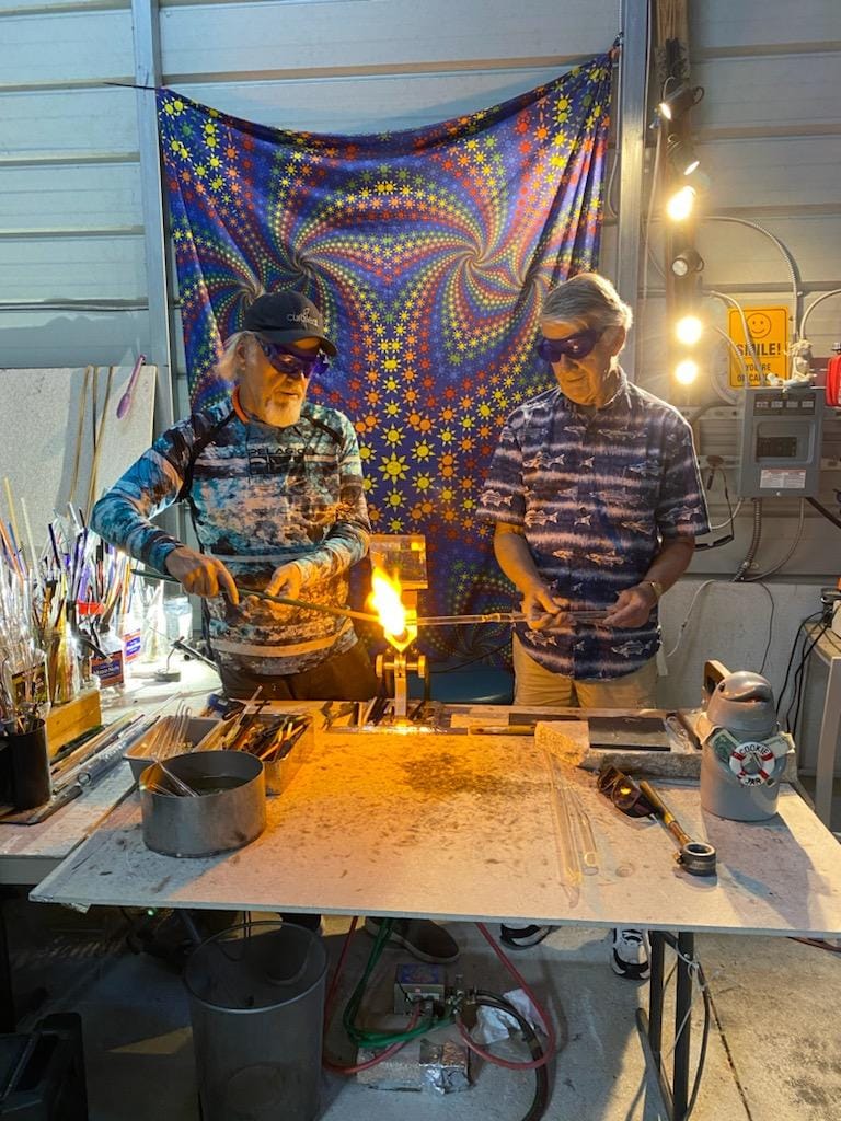 2 men working on a glass piece at Adventures in Glass Blowing in Naples