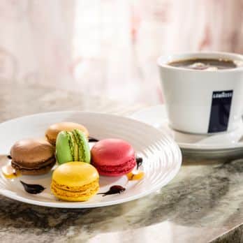 colorful macaroons next to Lavazaa coffee at Mon Paris Coffee Shop and Bakery in Fort Myers