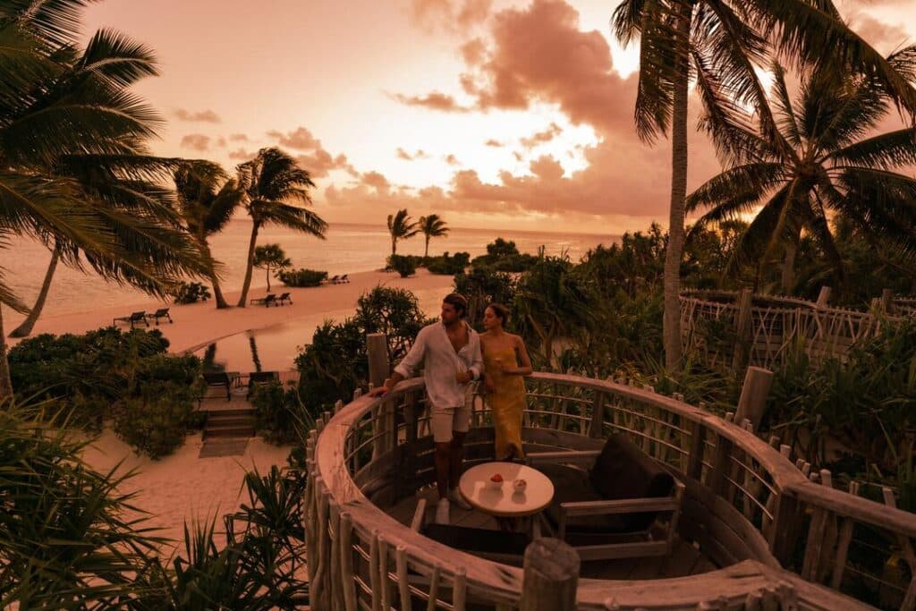 A honeymoon couple on the balcony of their all-inclusive room at The Brando